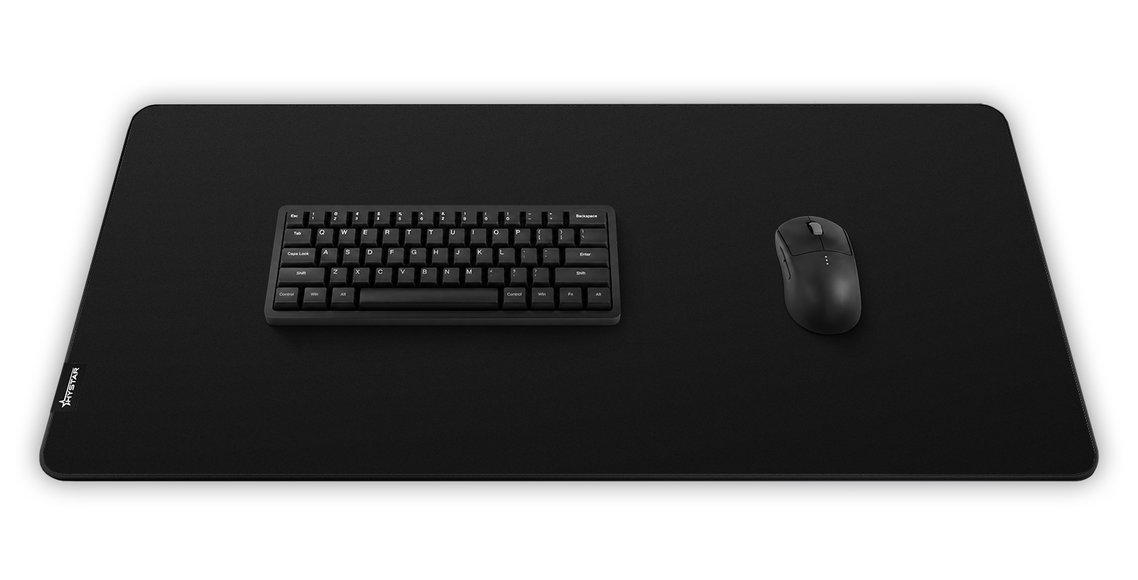Hystar Classic deskmat in Black, shown in a desk setup with keyboard and mouse. Black XXL (36" x 16"), Black XXXL (45" x 20")