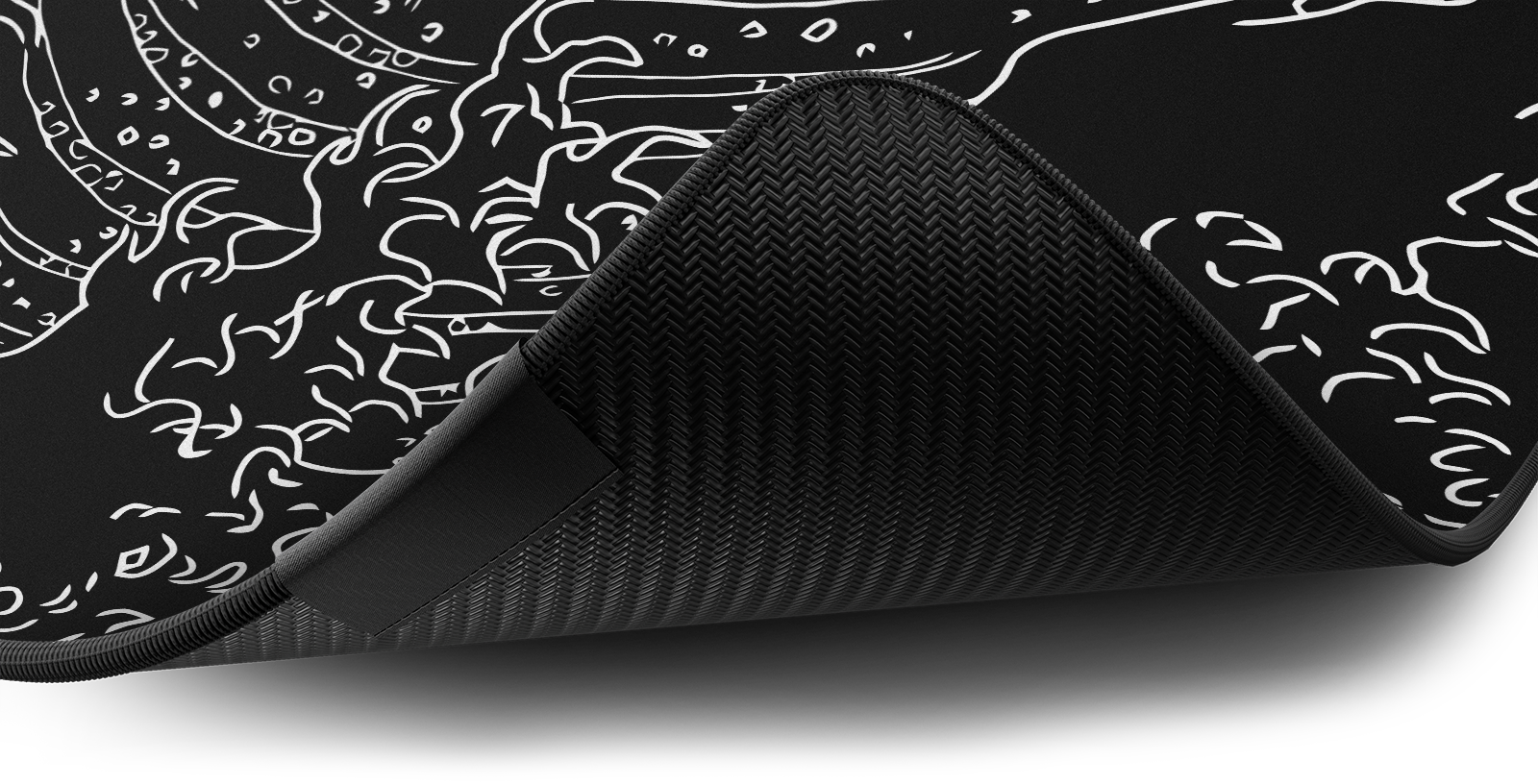 Close-up of the stitched edge and non-slip rubber base of the Hystar The Great Wave deskmat in Black. Black XXL (36" x 16"), Black XXXL (45" x 20")
